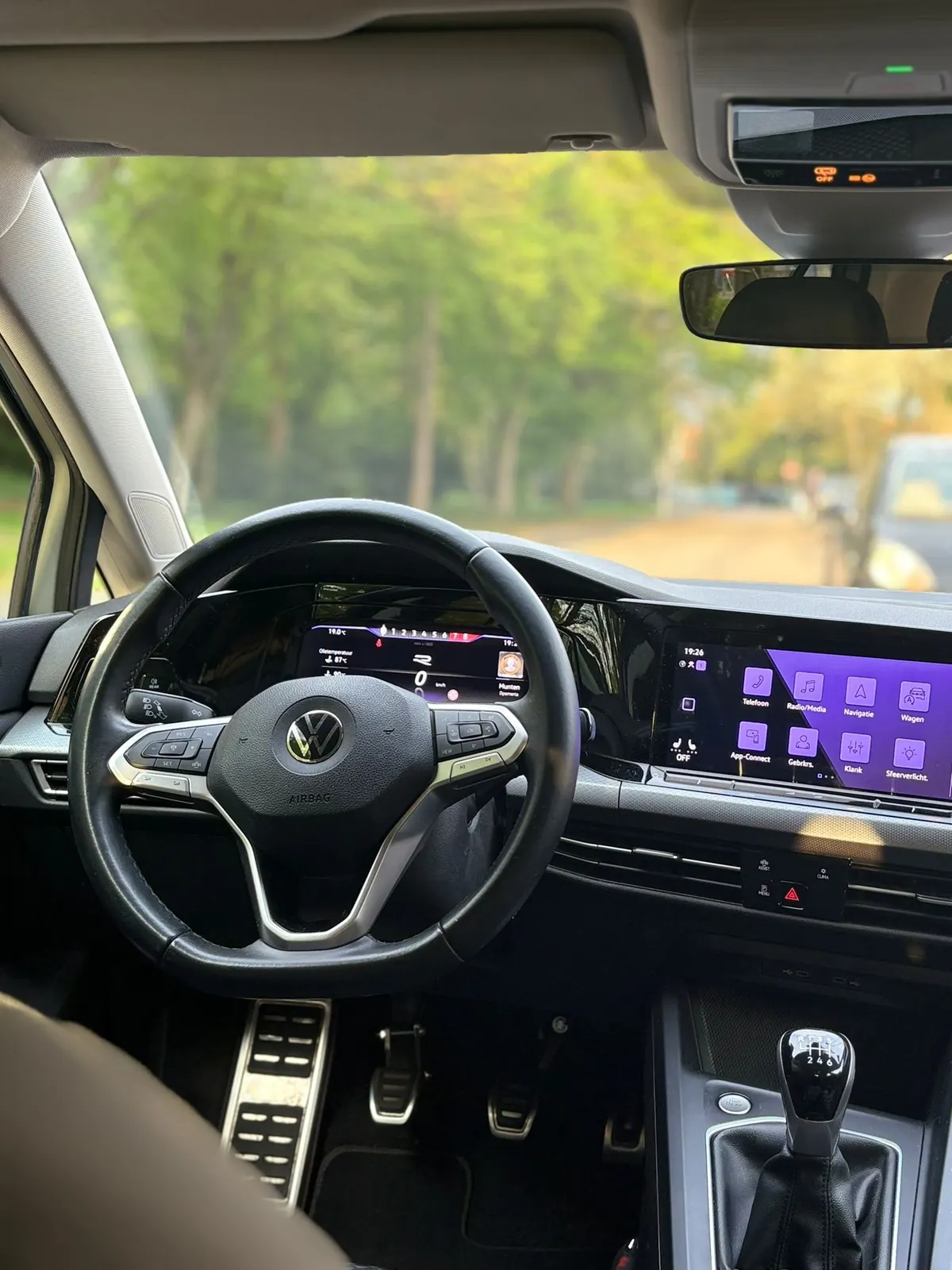 Interieur van de handgeschakelde Volkswagen Golf lesauto met stuur, digitaal dashboard en versnellingspook